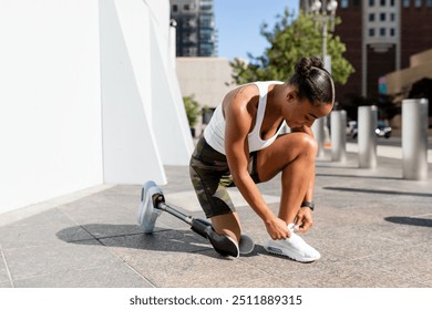 Woman with prosthetic leg tying her shoelaces - Powered by Shutterstock