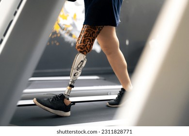 Woman with prosthetic leg using walking on treadmill while working out in gym. - Shutterstock ID 2311828771