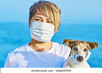 Woman in protective face mask and dog wearing medical mask too. Chinese Coronavirus disease COVID-19 is dangerous for pets, Pey ownwer avoid kissing their pet concept