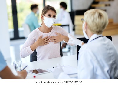 Woman With Protective Face Mask Having Appointment With A Doctor And Complaining About Chest Pain During Coronavirus Pandemic. 