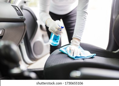 Woman With Protective Gloves Cleaning Car Seat With Microfiber Cloth And Spray Bottle Disinfectant.