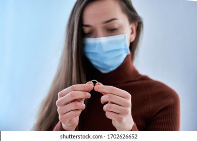 Woman In Protective Mask Holds Ring. Break Up Relationship After Living Together And Staying Home With Husband During Quarantine And Isolation Due To Coronavirus Covid Epidemic. Divorce Concept 