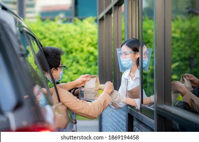 Woman In Protective Mask Taking Coffee At Drive Thru During Coronavirus Outbreak, Concept For New Normal Between Covid 19 Pestilence.