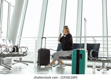 Woman In Protective Mask Waiting For Plane At Airport, Waiting Area In Airport Terminal. Passenger At Airport Waiting Area