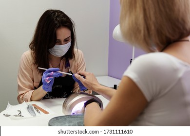 Woman In Protective Medical Mask And Manicurist. Beauty Salons, Manicure, Nail Care Opened! Covid-19, Coronavirus . Quarantine Period In City Is Over! Small Business And Covid-19, Coronavirus