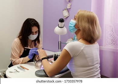 Woman In Protective Medical Mask And Manicurist. Beauty Salons, Manicure, Nail Care Opened! Covid-19, Coronavirus . Quarantine Period In City Is Over! Small Business And Covid-19, Coronavirus