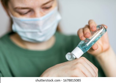 Woman in a protective medical mask treats her hands with an antibacterial gel. Prevention of infection and dissemination of coronavirus, quarantine - Shutterstock ID 1678815085