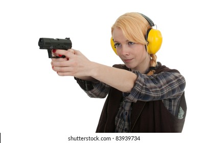 woman in protective receivers aiming a pistol at shooting range
