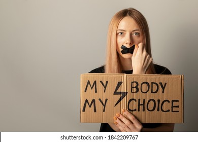 A Woman Protests Against The Ban On Abortion In Poland. A Feminist Defends Women's Rights. Conceptual Photo With Protest Symbols.