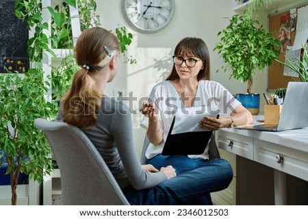 Woman psychologist, counselor talking with girl child