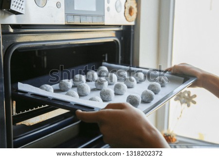 woman pulls cookies from the oven