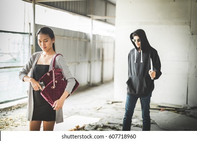 Woman Pulls A Gun From Her Swanky Purse While The Thief Stood In The Back. Conceal Carry Weapon For Protection Themselves Concept. Selective Focus.