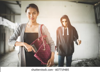 Woman Pulls A Gun From Her Swanky Purse While The Thief Stood In The Back. Conceal Carry Weapon For Protection Themselves Concept. Selective Focus.