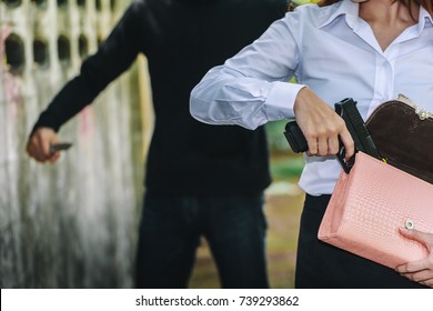 Woman Pulls A Gun From Her Swanky Purse. Conceal Carry Weapon For Protection Themselves Concept. Selective Focus To Gun.