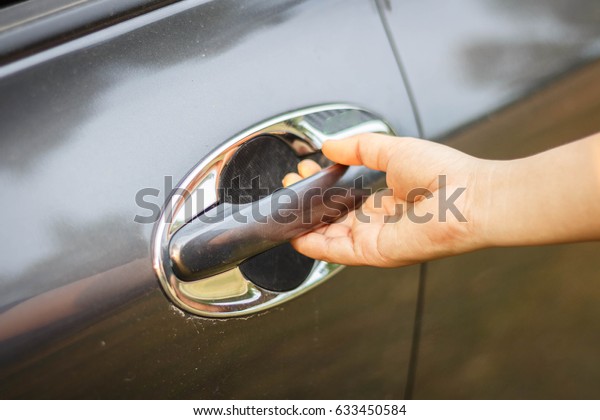 Woman pulls hand on car\
door.