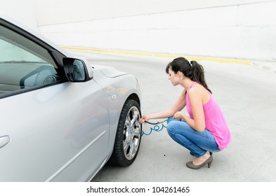 Woman Pumping Air To Car Tires And Checking Pressure Before Travel. Copy Space.