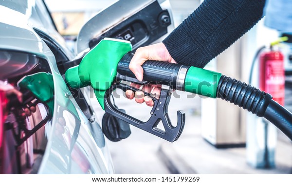 Woman\
pumping gasoline fuel in car at gas\
station.