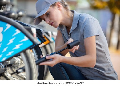 Woman Pumping Up A Tyre With Bike Pump