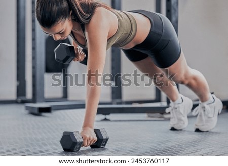 Woman, push up and dumbbell in gym for fitness, exercise and training for strong muscle. Female person, bodybuilder and athlete for sport and plank, power and equipment for workout or weightlifting