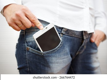 woman pushing big mobile phone in jeans pocket