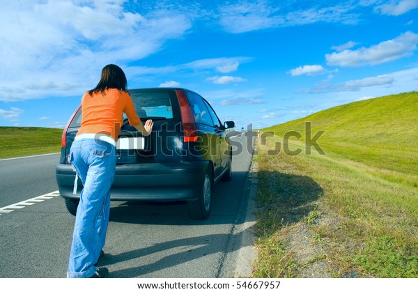 woman pushing a
car