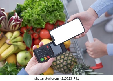 Woman pushing a full shopping cart and paying for groceries with her smartphone, mobile payments concept, top view - Powered by Shutterstock