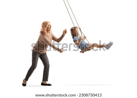 Woman pushing a little girl on a swing isolated on white background