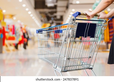 Woman Pushing Shopping Cart In Shopping Mall