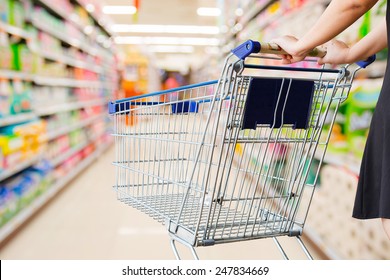 Woman Pushing Shopping Cart In Supermarket