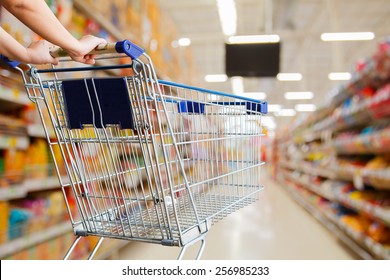 woman pushing shopping cart in supermarket