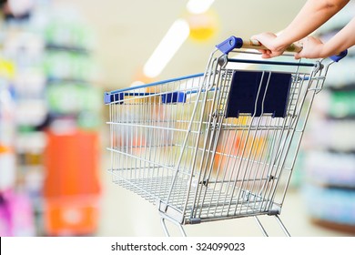 Woman Pushing Shopping Cart In Supermarket