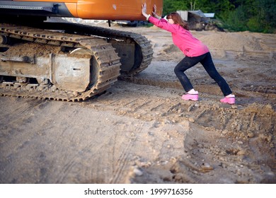 Woman Pushing A Tractor Outdoors