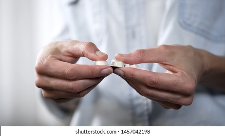 Woman pushing a white tablet out of blister package, medication, pharmaceuticals - Shutterstock ID 1457042198