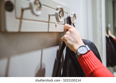 woman put backpack on stylish wall hanger - Powered by Shutterstock