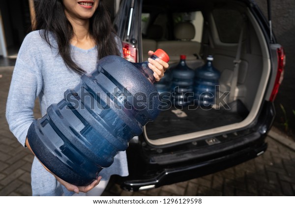 woman put a gallon of water\
in the car trunk at home. wanted to purchase the refill or by the\
new one