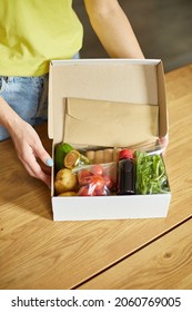 Woman Put On The Table Food Box Meal Kit Of Fresh Ingredients Order From A Meal Kit Company, Delivered, Cooking At Home.