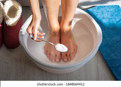 Woman Put Spoon Of Baking Soda In Bath With Hot Water For His Feet. Homemade Bath Soak For Dry Feet Skin. 