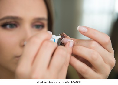 Woman Puting Cosmetic Glue On Fake Eyelashes During Makup