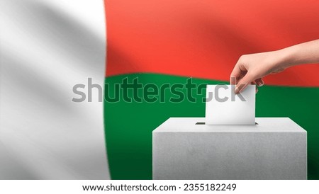 Woman puts ballot paper in voting box on Madagascar flag background. Election concept.