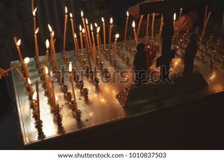 a woman puts a candle in the Church
