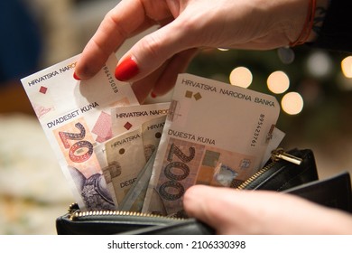 a woman puts Croatian Kuna in her wallet. The woman is holding Croatian money. Concept showing the Croatian economy.