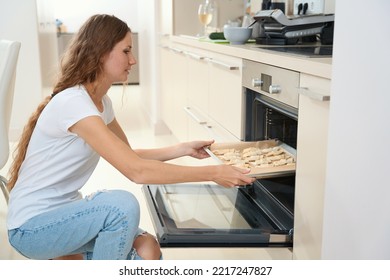 Woman Puts Croissant Blanks On Baking Sheet Into The Oven