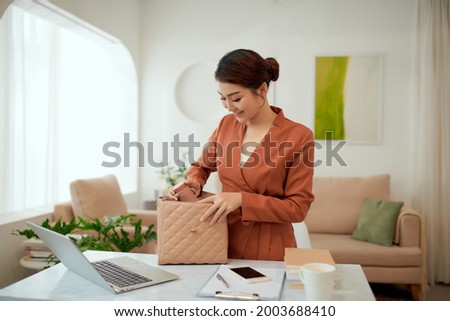 A woman puts essential things in a bag