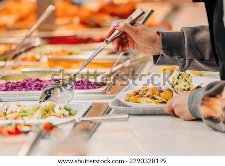 woman puts food on her plate at the buffet, closeup view