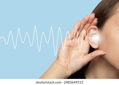 A woman puts her hand to her ear and listens, isolated on a blue background with sound waves. Hearing problems, ear diseases, noise. Concept of testing and hearing loss. Audiometry