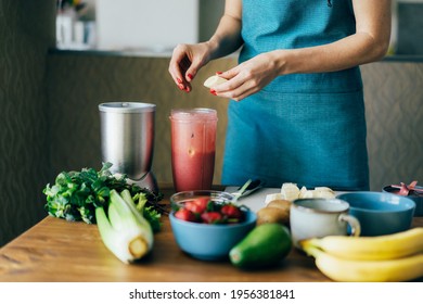 A Woman Puts The Ingredients In A Blender Bowl To Make A Spring Fruit And Berry Smoothie. Cooking At Home In The Kitchen, Care And Nutrition And Health.