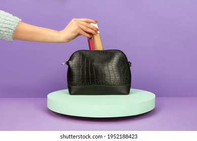 Woman Puts Makeup In The Bag On Purple Ground