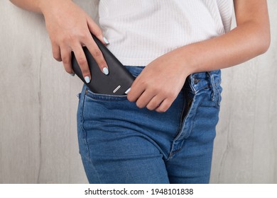 Woman puts the mobile phone in her pocket.