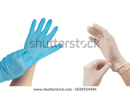 Woman puts on blue rubber gloves. Isolated on white.