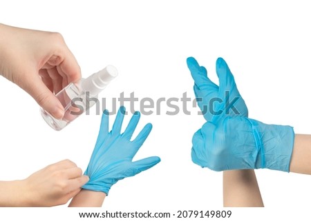 Woman puts on blue rubber gloves. Isolated on white.